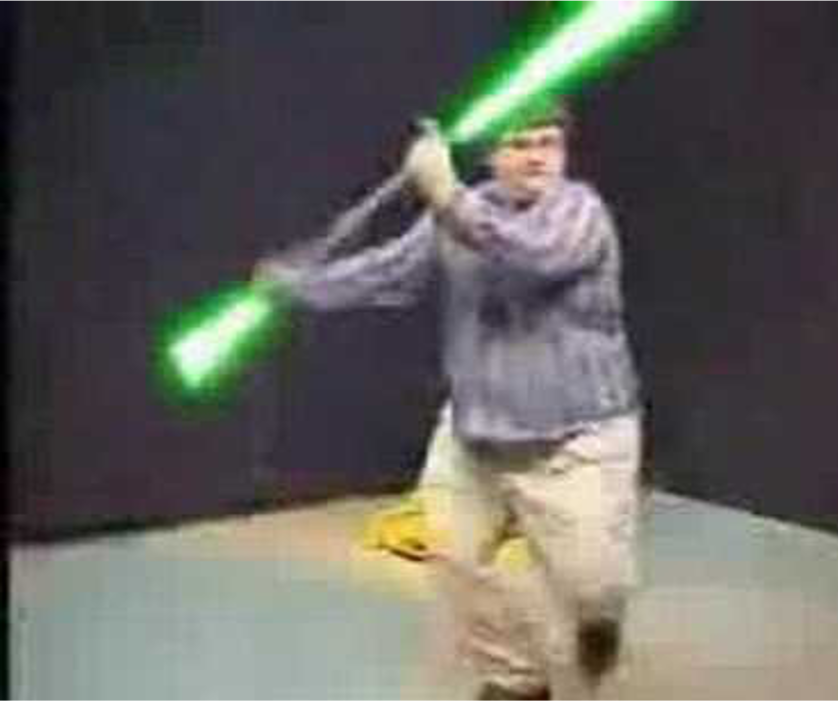 Still from Star Wars Kid meme showing Ghyslain Raza twirling a pole that has been edited to be a double-edged lightsaber. 